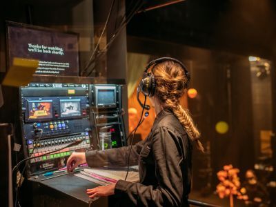 Deputy Stage Manager working at a cueing desk overlooking the stage